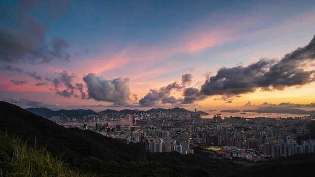 Amazing colourful sunrise cloud formations time lapse above high rise Kowloon city skyline