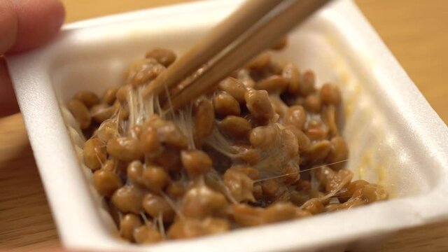 納豆をゆっくり箸でかき混ぜる（クローズアップ）