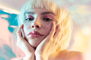 Young blond teen girl with  smooth skin and modern fashion makeup  with sparkles on face. 