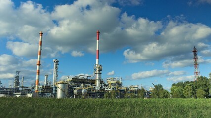 Fototapeta na wymiar Oil refinery in sunny beautiful weather with clouds in background