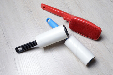 brushes for cleaning clothes. sticky and a bristled brush, lie on a light-colored countertop.
