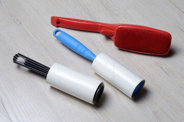 brushes for cleaning clothes. sticky and a bristled brush, lie on a light-colored countertop.