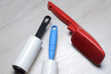 brushes for cleaning clothes. sticky and a bristled brush, lie on a light-colored countertop.