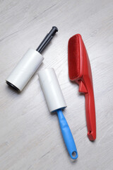 brushes for cleaning clothes. sticky and a bristled brush, lie on a light-colored countertop.