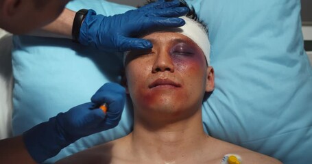 Paramedic checking up and using flashlight on injured young man