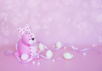 Obraz na płótnie Canvas The pink bunny with white chocolate eggs and purple ribbon on pink background with bokeh effect 