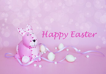 Obraz na płótnie Canvas The pink bunny with white chocolate eggs and purple ribbon on pink background with bokeh effect and happy easter lettering