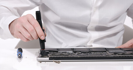 Service worker repairing cleaning dust laptop motherboard circuit board cooler with brush in white...