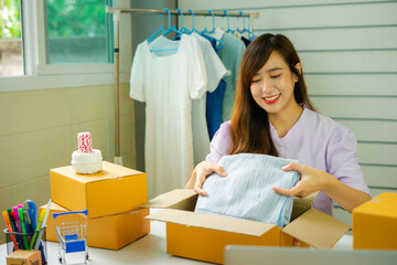 Startup small business SME, Entrepreneur owner is smiling and packing products to customers after she succeeded in thinking differently in online sme business.