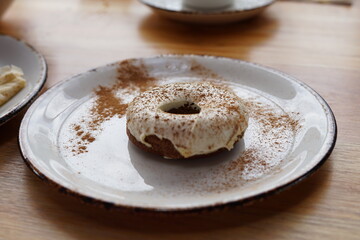 carrot donuts with white icing on white plate