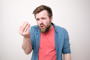 A disgruntled Caucasian man swears at someone and makes a hand gesture. White background.