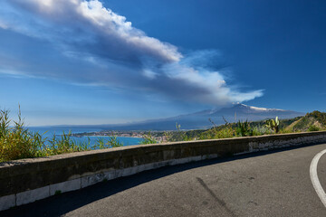 Fototapeta premium volcano in Sicily taken from the road that climbs to get to Taormina on a beautiful sunny day in spring 2021, you can see the station and Giardini Naxos with the whole 