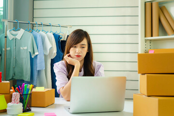 Portrait of young Asian businesswoman ีusing laptop in-home office. Beautiful girl at desk computer take-home order. Startup business Asia woman online sme telemarketing.