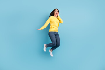 Fototapeta premium Full size photo of nice stressed brunette long hairdo lady jump wear shirt jeans sneakers isolated on blue color background