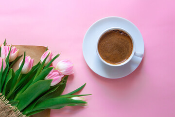 March 8, International Women's Day. number eight, consisting of a cup of coffee and a donut with a pink filling, next to pink tulips on a pink background. space for text