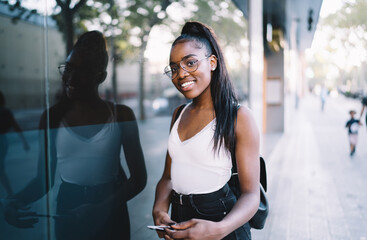 Half length portrait of happy dark skinned woman in optical spectacles for provide eyes correction...