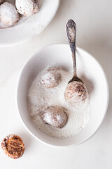 Homemade cottage cheese donuts balls with powdered sugar in a bowl on a light background. Beautiful breakfast. 