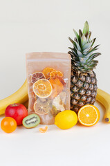 Fresh fruits pineapple, banana, orange, kiwi, lemon and tangerines with dehydrated slices packed in craft