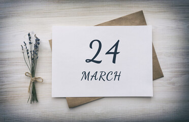 march 24. 24th day of the month, calendar date. White blank of paper with a brown envelope, dry bouquet of lavender flowers on a wooden background. Spring month, day of the year concept