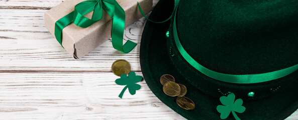 Leprechaun hat, gold coins, clover shamrock and gift with green ribbon on white background. Good...