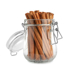 Aromatic dry cinnamon sticks in glass jar on white background