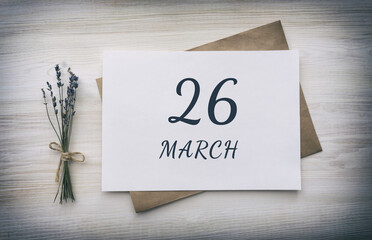 march 26. 26th day of the month, calendar date. White blank of paper with a brown envelope, dry bouquet of lavender flowers on a wooden background. Spring month, day of the year concept