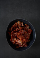 fried bacon on black surface