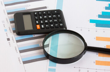 Calculator with magnifying glass on the diagrams