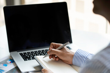 close-up of a male accountant or banker who notes and checks investment results, calculates financial savings, calculates annual taxes and economic concepts. Financial calculation concept