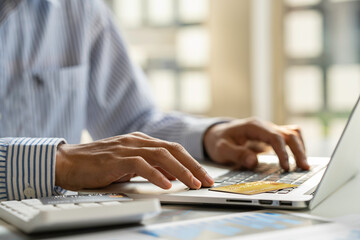 Asian male finance Online payment, Man's hands holding a credit card and using a smartphone for online shopping