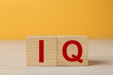 Wooden cubes with abbreviation IQ on table. Space for text