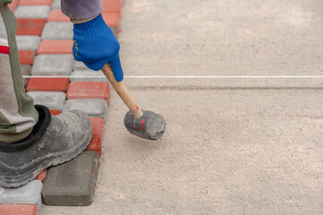 Bricklayer laying paving slabs. Paving stones for laying paths