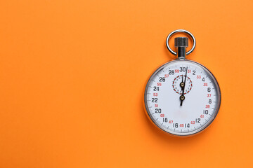 Vintage timer on orange background, top view. Space for text