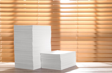 Stacks of paper sheets on wooden table. Space for text