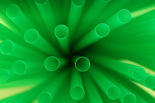 Heap of green plastic straws for drinks, closeup