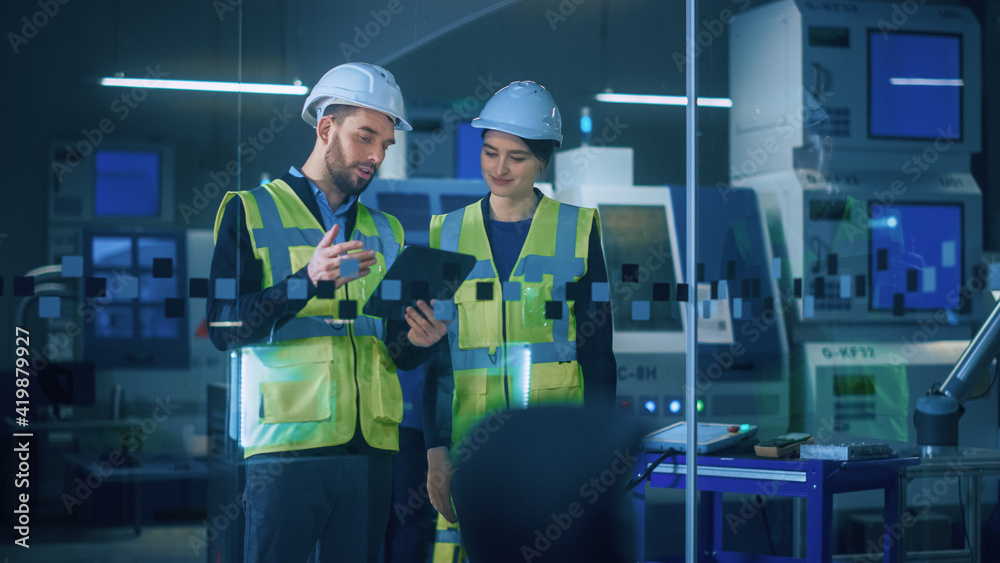 Poster modern factory: female and male engineers wearing safety jackets, hardhats standing in industrial wo