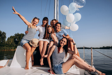 Bachelorette party and vacation concept .Girls waving on boat or yacht