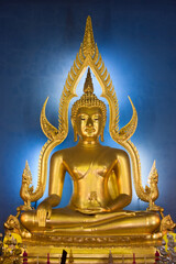 Fototapeta premium A Buddha statue in the Benchamabophit temple, on a blue background.