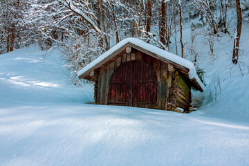Old wooden hut in the Alps in winter, Germany.