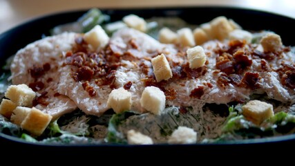 Fresh Cezar salad with romaine lettuce,  chicken, bacon and bread.