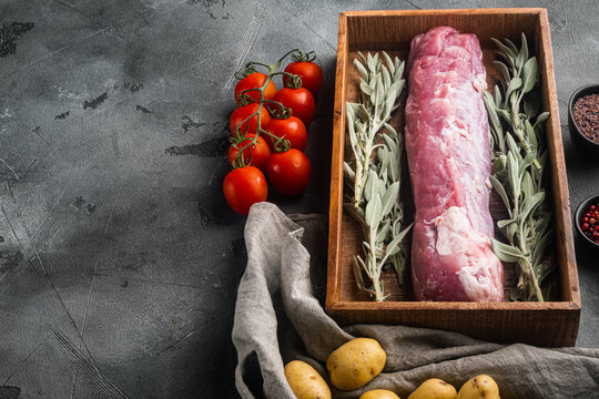 Raw Pork fillet with sage, in wooden box, on gray stone background , with copyspace  and space for text
