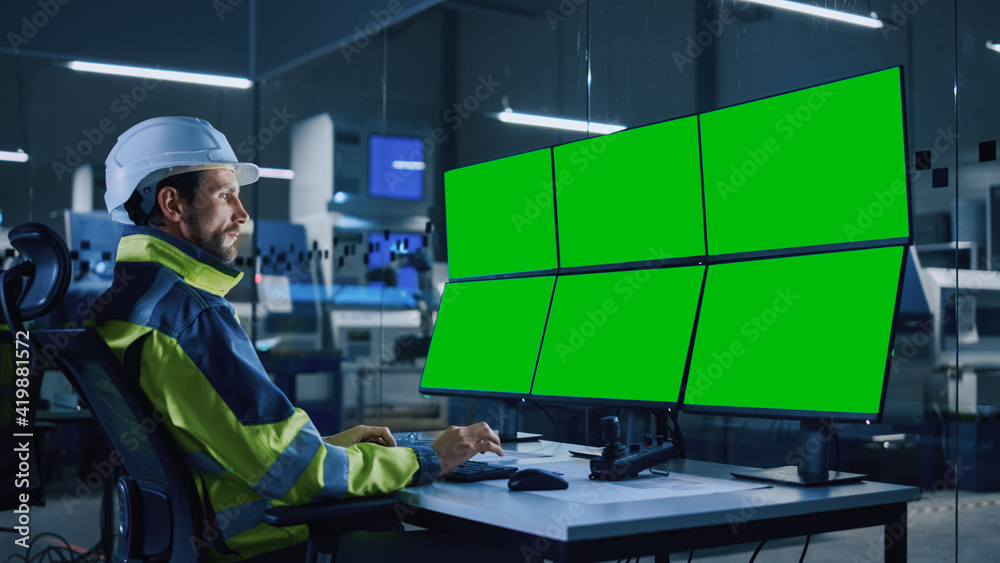 Fototapete Industry 4.0 Modern Factory: Facility Operator Controls Workshop Production Line, Uses Computer with 6 Displays Showing Green Screens Chroma Key Mock up Template. Controls Machine Operation Processes.