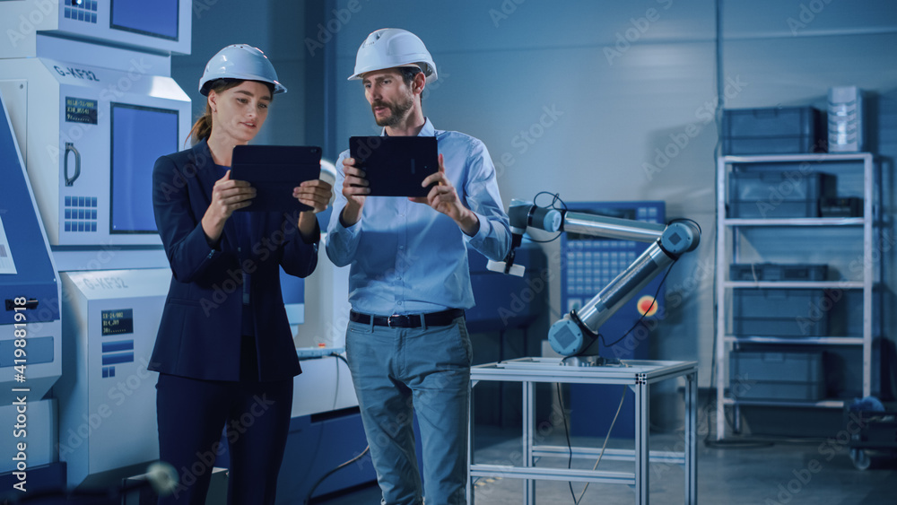 Poster Portrait of Two Professional Engineers Use Industrial Digital Tablets to Work with Augmented Reality. Great Template Shot for Augmented Reality. Factory Workshop with CNC Machinery.