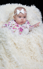 Beautiful baby in a fur blanket. The girl is four months old. Children under one year old.