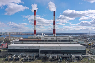 Pipes with white smoke. Pipes of a city gas boiler room with white smoke against a sky. Top view from a drone.	