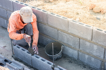 Workers are laying blocks of bricks.
