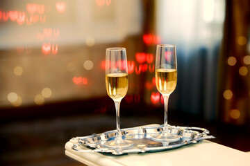 Two glasses of champagne against a background of bokeh spots. Festive romantic background.