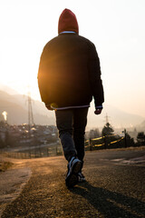 person walking towards the sun