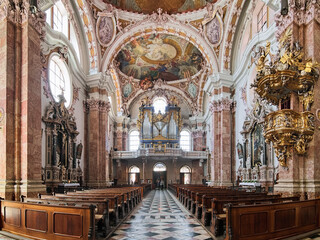 Fototapeta na wymiar Innsbruck, Austria. Panoramic view of interior of Innsbruck Cathedral (Cathedral of St. James) with main organ. The cathedral was built in 1717-1724.