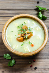 Cream mushroom soup croutons  in a bowl on wooden background. Space for text.